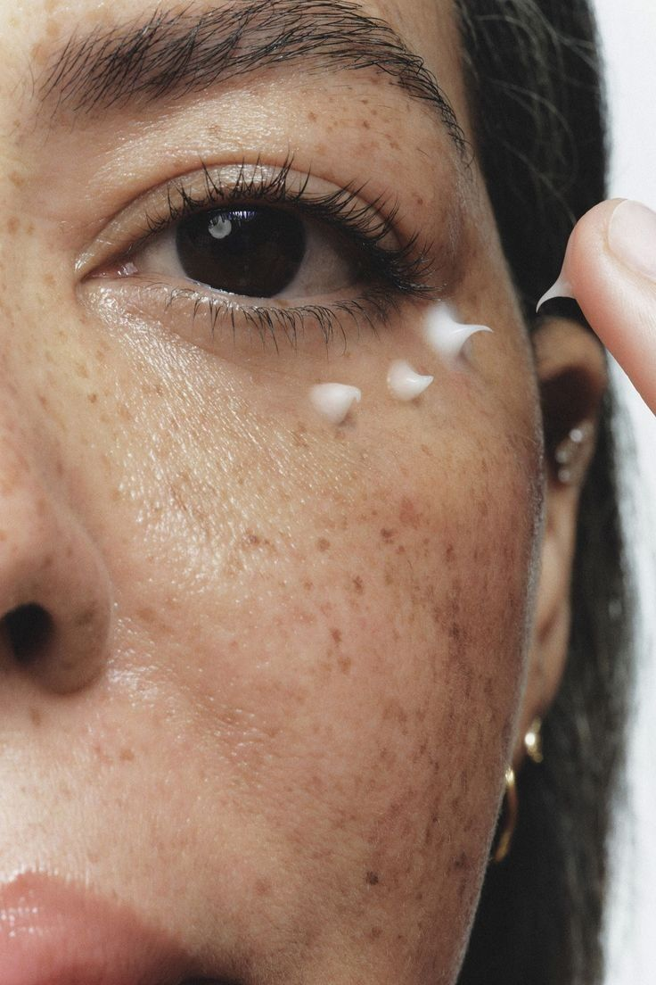 Gros plan d'un visage avec une noisette de crème près de l'œil