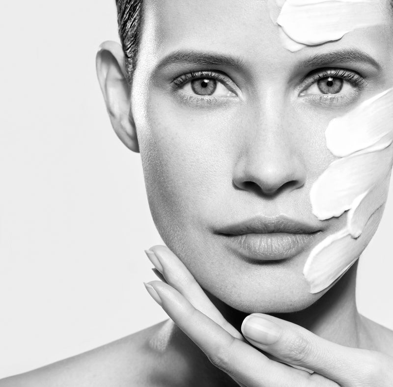 Visage de femme avec une crème appliquée sur la joue