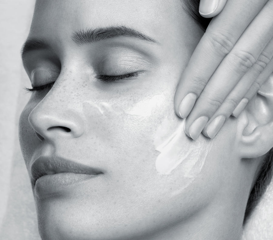 Application d'un masque crème sur le visage d'une cliente